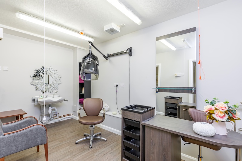 salon room with hair dryer and mirror